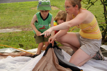 Young campers learning how to put up a tent