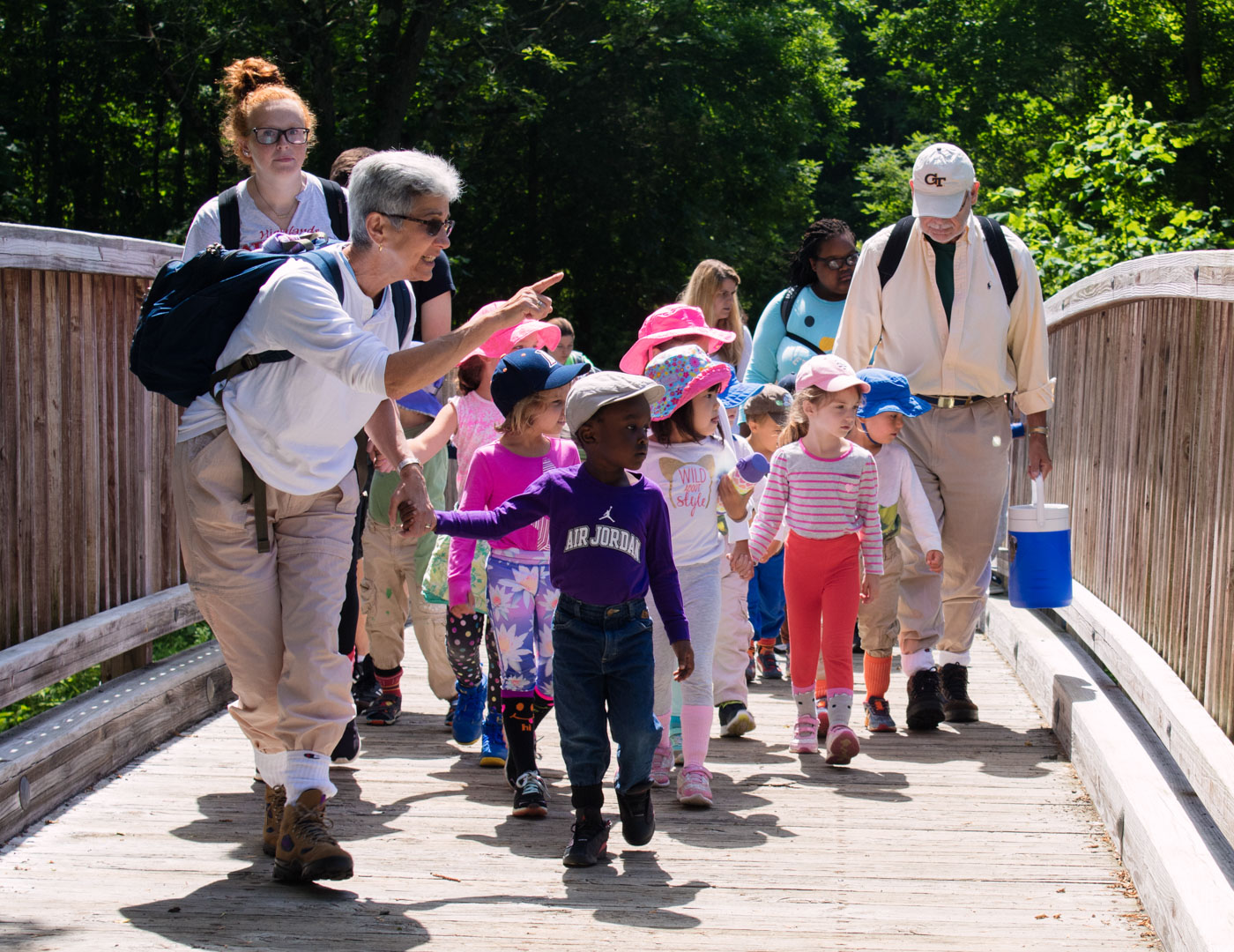 Young campers walking with counselors over a bridge on a day hike