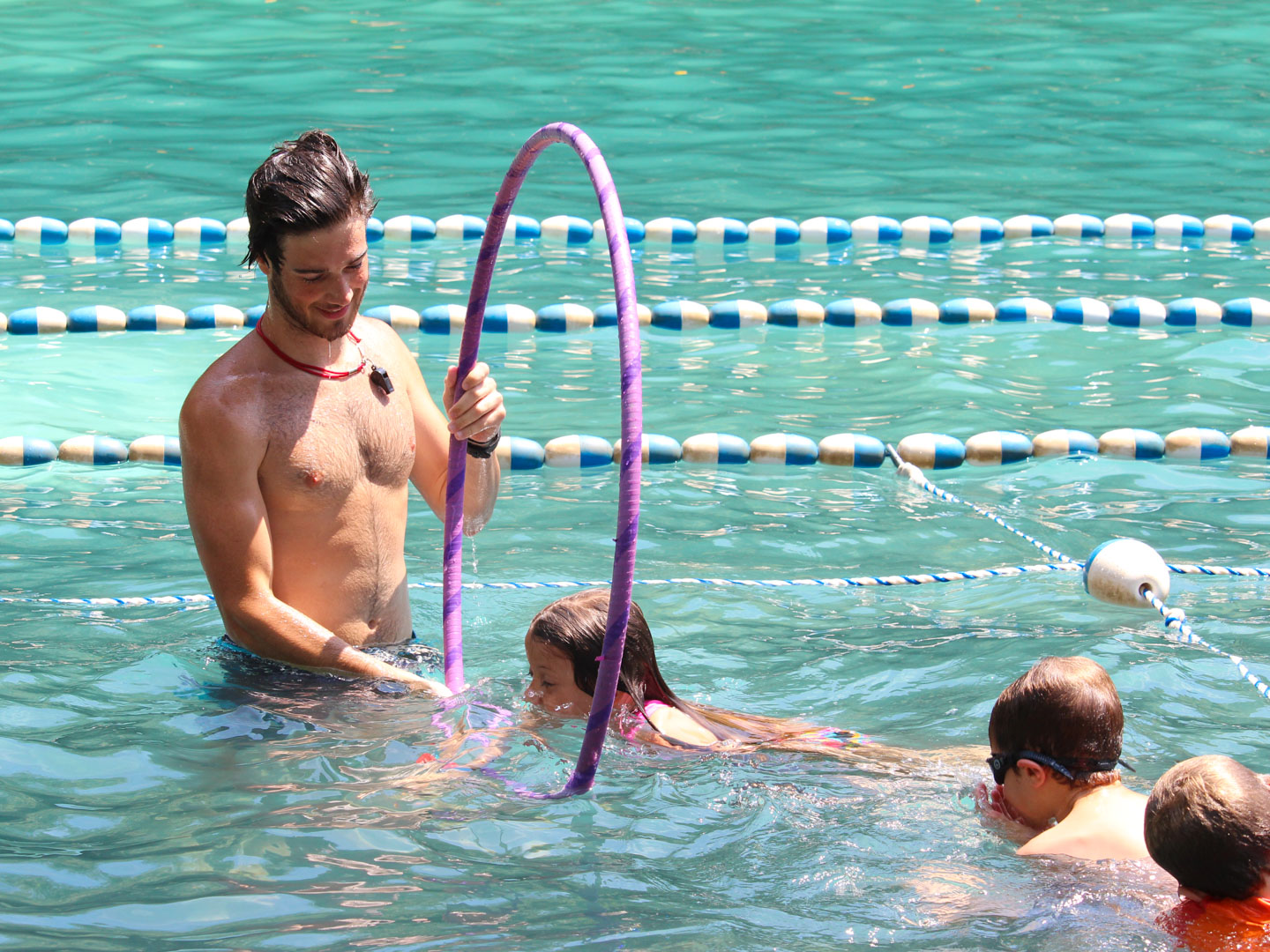 Counselor giving campers swim lessons
